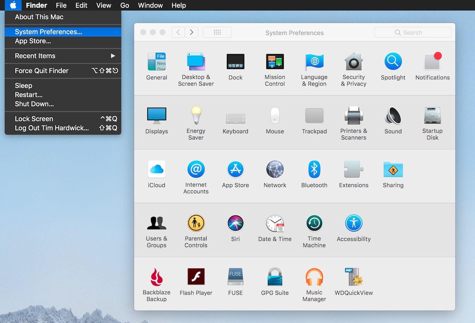 Image shows Mac home screen with the System preferences option to proceed to changing Airpod name